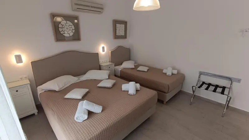 Une chambre lumineuse avec deux lits et des oreillers décorés.