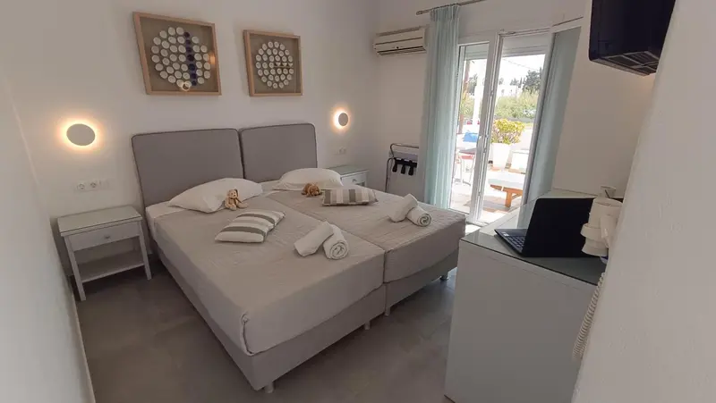 Une chambre lumineuse avec un grand lit et un bureau.