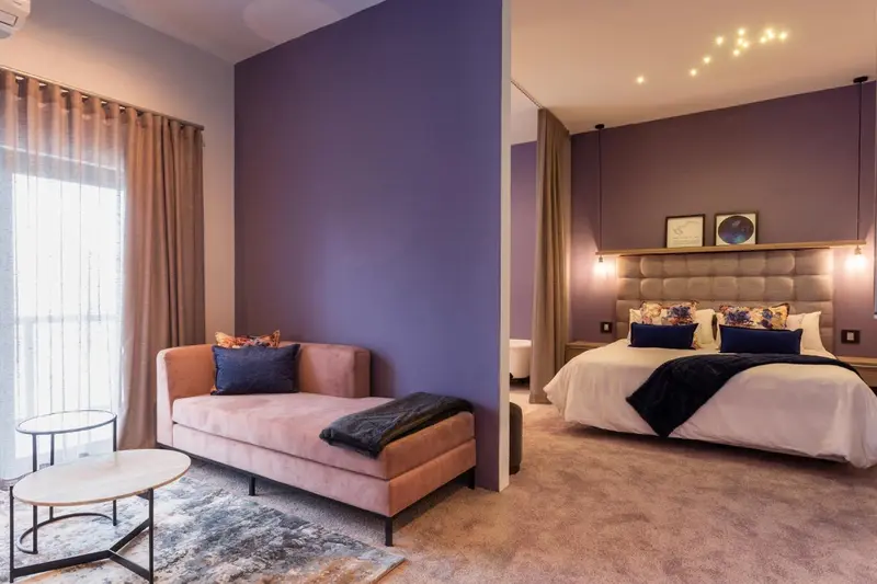 Une chambre moderne avec un canapé et un lit double.