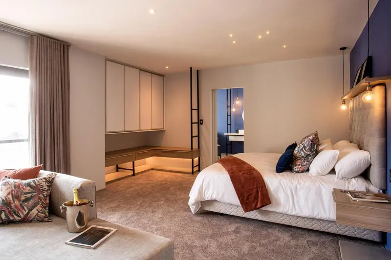 Une chambre spacieuse avec un grand lit et un coin salon.