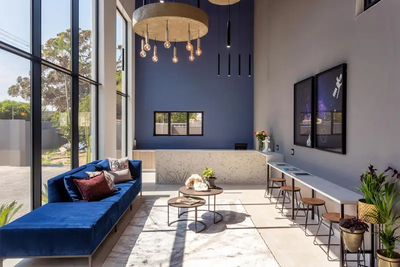 Un espace d'accueil lumineux avec un canapé bleu et un comptoir.
