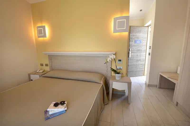 Une chambre lumineuse avec un grand lit et une décoration sobre.