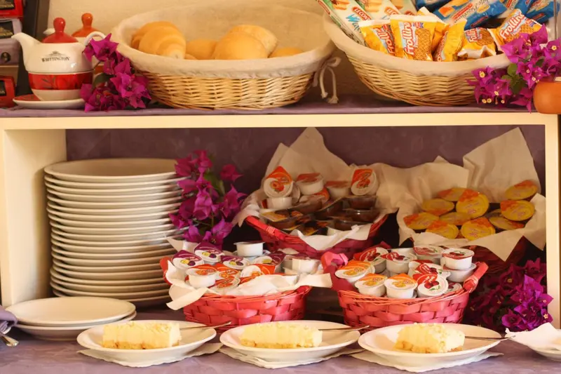 Assortiment de viennoiseries et de confitures présentées sur un buffet.