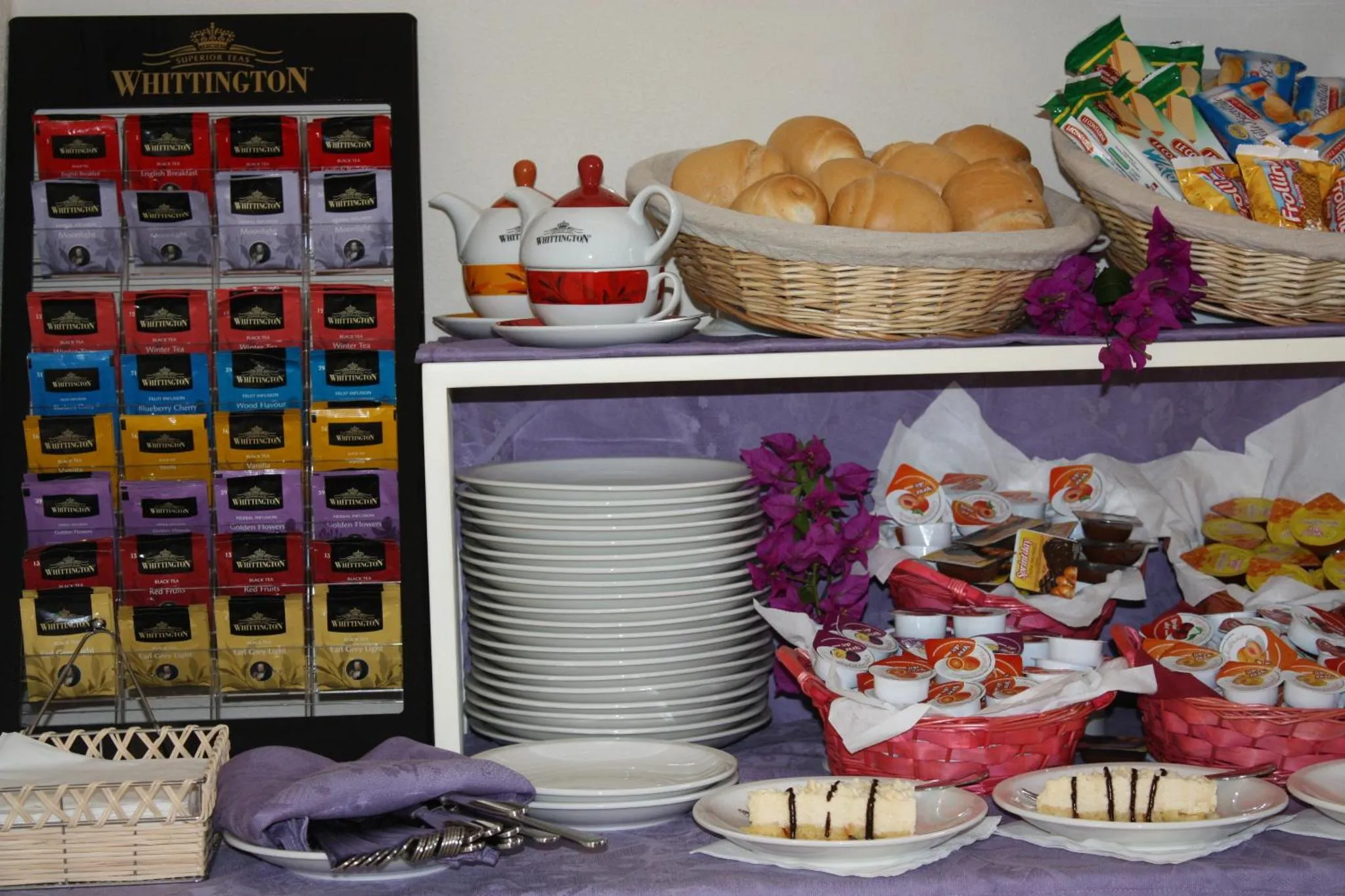 Une table garnie de boissons chaudes, de viennoiseries et de fruits.