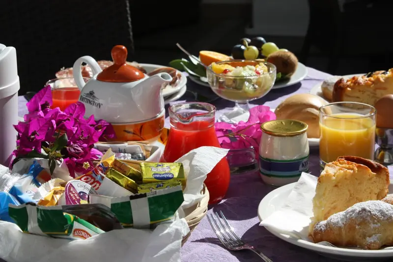 Une table est dressée avec un copieux petit-déjeuner.