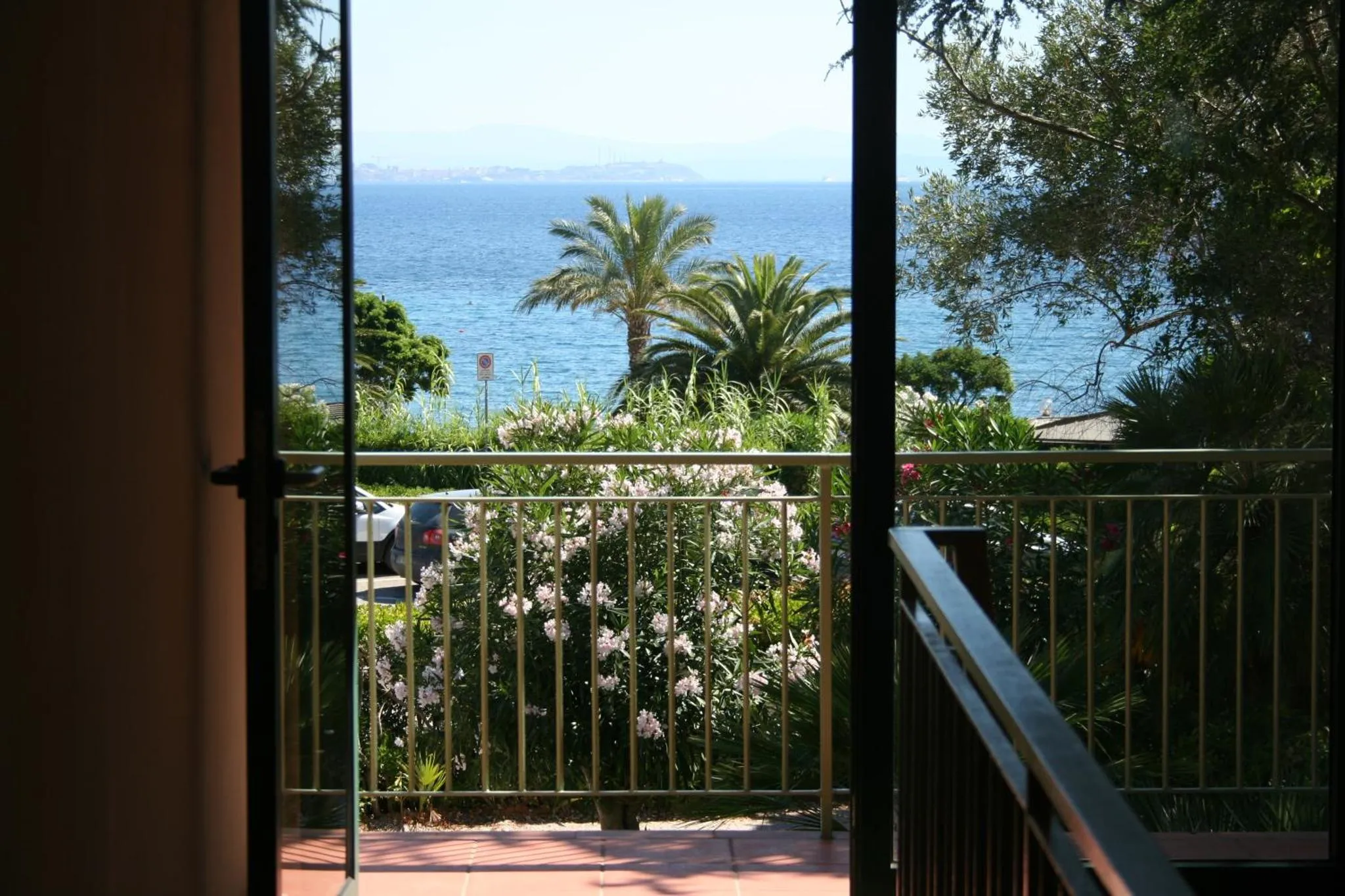 Vue sur la mer depuis une terrasse fleurie.