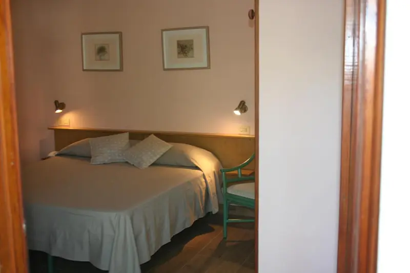 Une chambre lumineuse avec un lit double et des coussins.