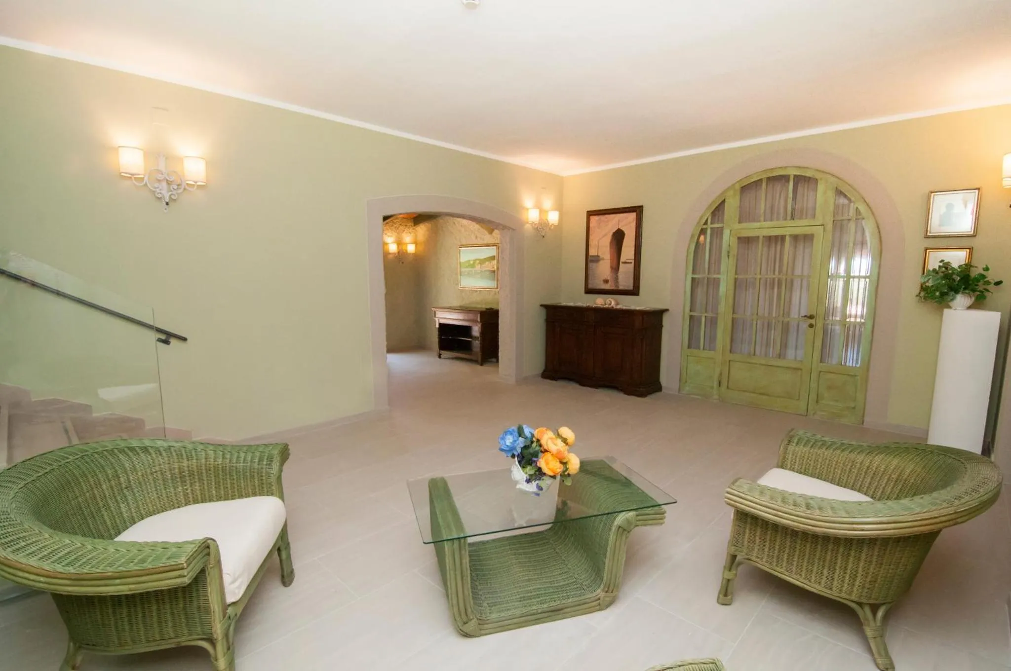 Espace de détente lumineux avec mobilier en rotin et décoration florale.