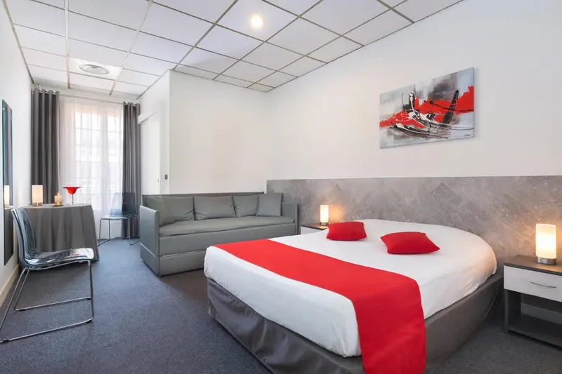 Une chambre moderne avec un canapé et un lit rouge vif.