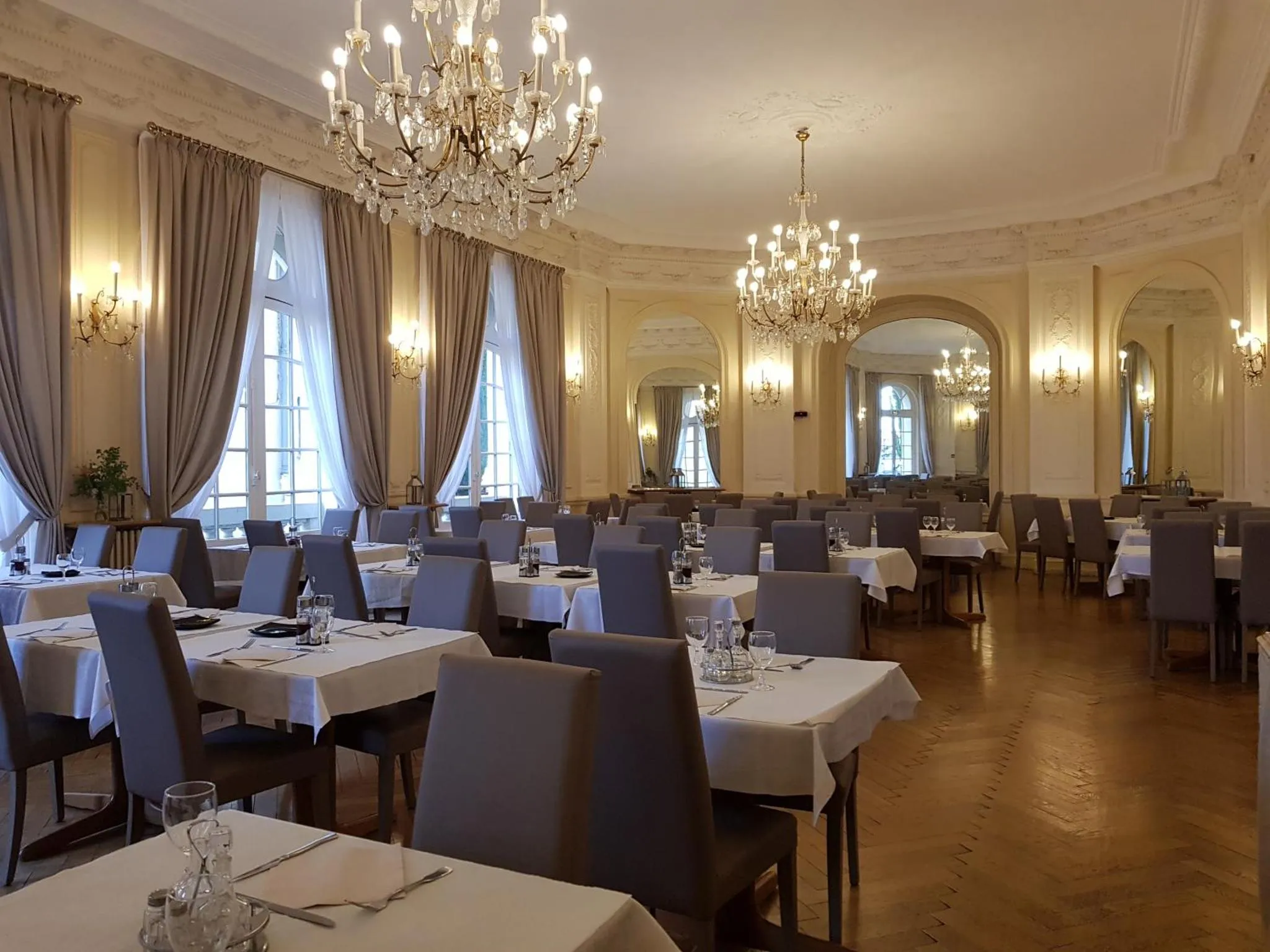 Une salle lumineuse avec des tables dressées pour un repas.