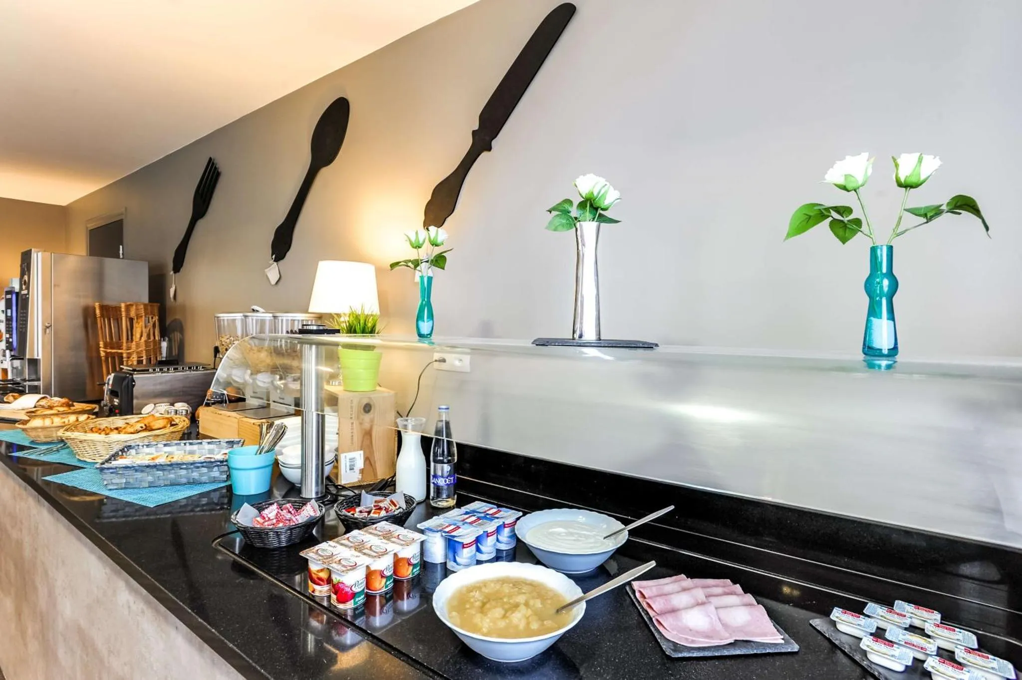 Un comptoir de buffet propose des viennoiseries, des fruits et des boissons.