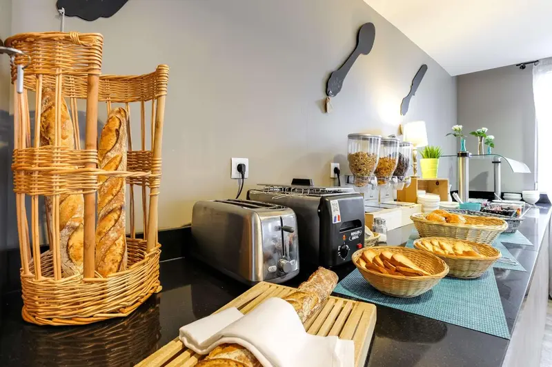 Des viennoiseries et du pain sont présentés sur un comptoir noir.