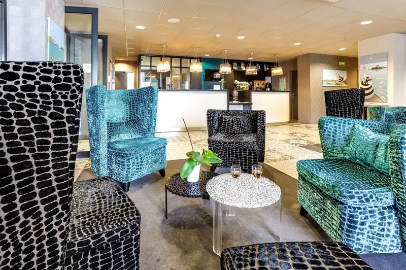 Un espace d'accueil moderne avec des fauteuils et un comptoir.