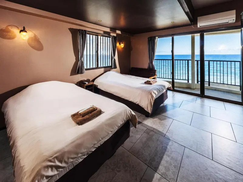 Une chambre lumineuse avec deux lits simples donnant sur la mer.