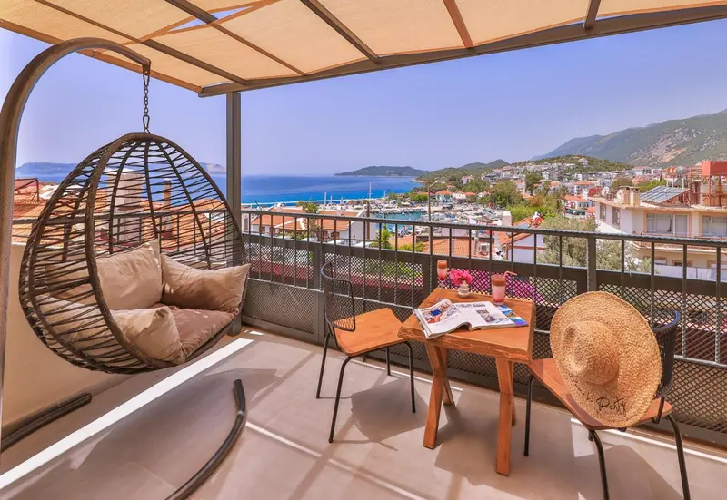 Terrasse avec mobilier d'extérieur et vue sur la mer et la ville.