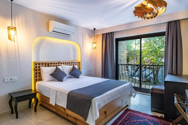 Une chambre lumineuse avec un grand lit et un accès à une terrasse.