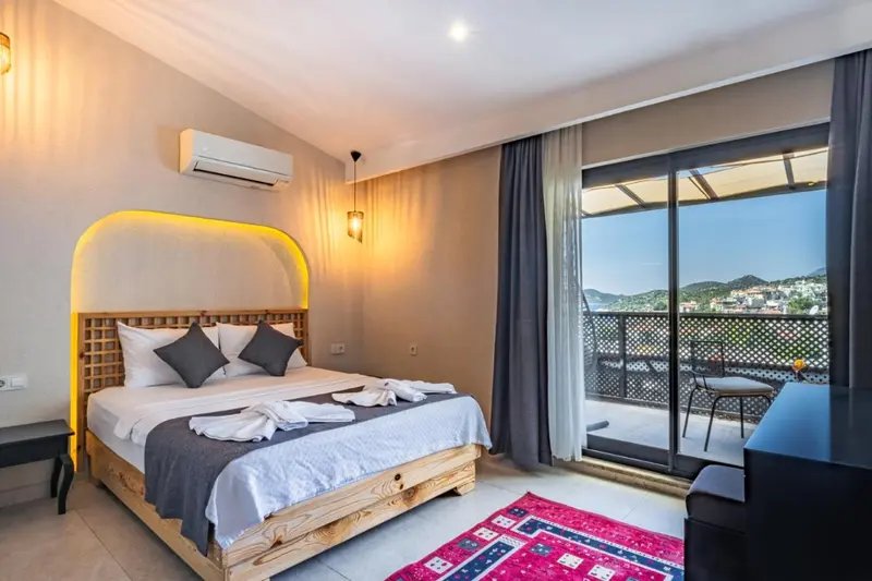 Une chambre lumineuse avec un grand lit et un accès à un balcon.