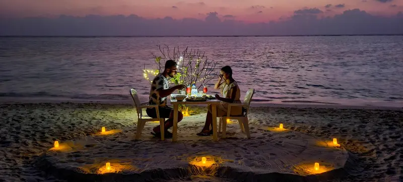 Dîner romantique en bord de mer au coucher du soleil.