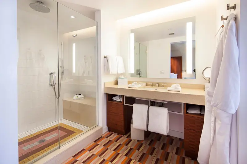 Une salle de bain lumineuse avec une douche à l'italienne et un double lavabo.
