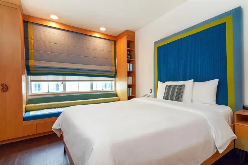 Une chambre lumineuse avec un grand lit et une décoration colorée.