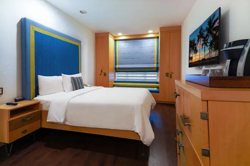 Une chambre lumineuse avec un grand lit et une télévision.