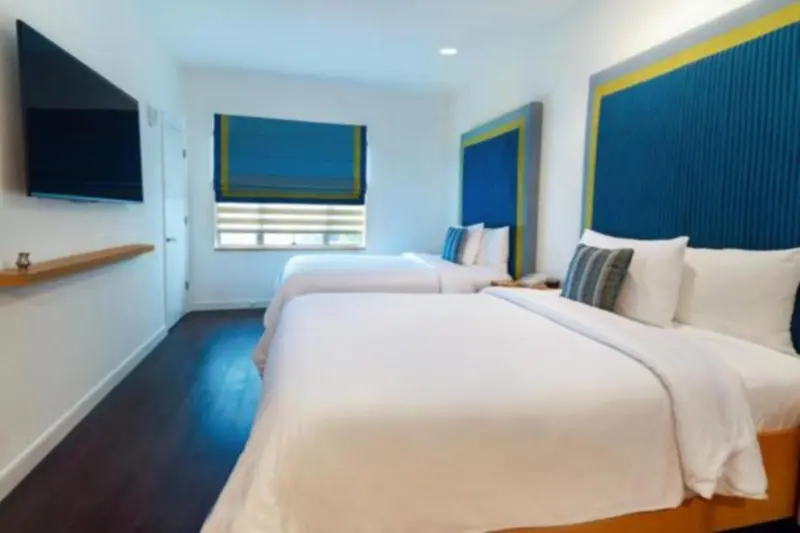 Chambre lumineuse avec deux lits simples et une décoration moderne.