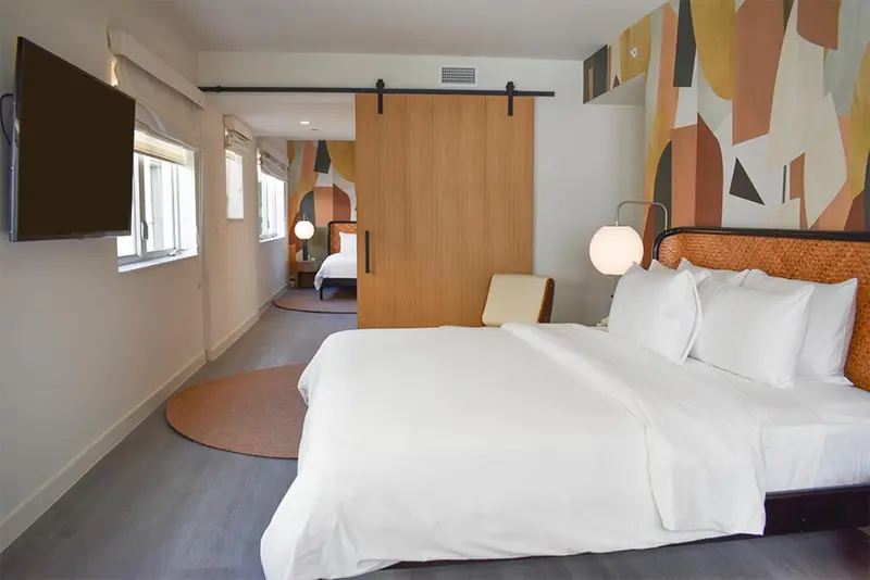 Une chambre lumineuse avec un grand lit et un mur décoratif.