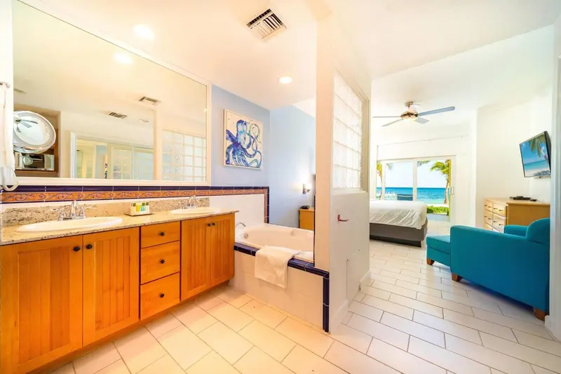 Une salle de bain lumineuse s'ouvre sur une chambre avec vue sur la mer.