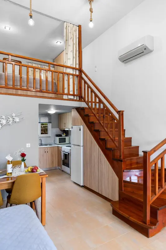 Une chambre mansardée avec un coin cuisine et une table à manger.