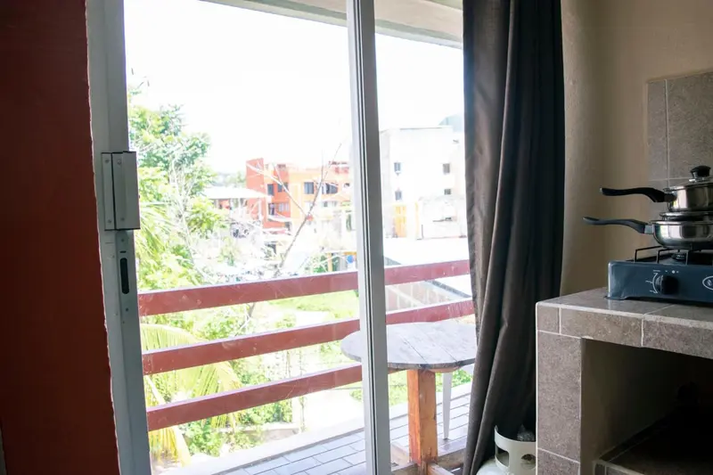 Une cuisine s'ouvre sur un balcon avec vue sur la ville.