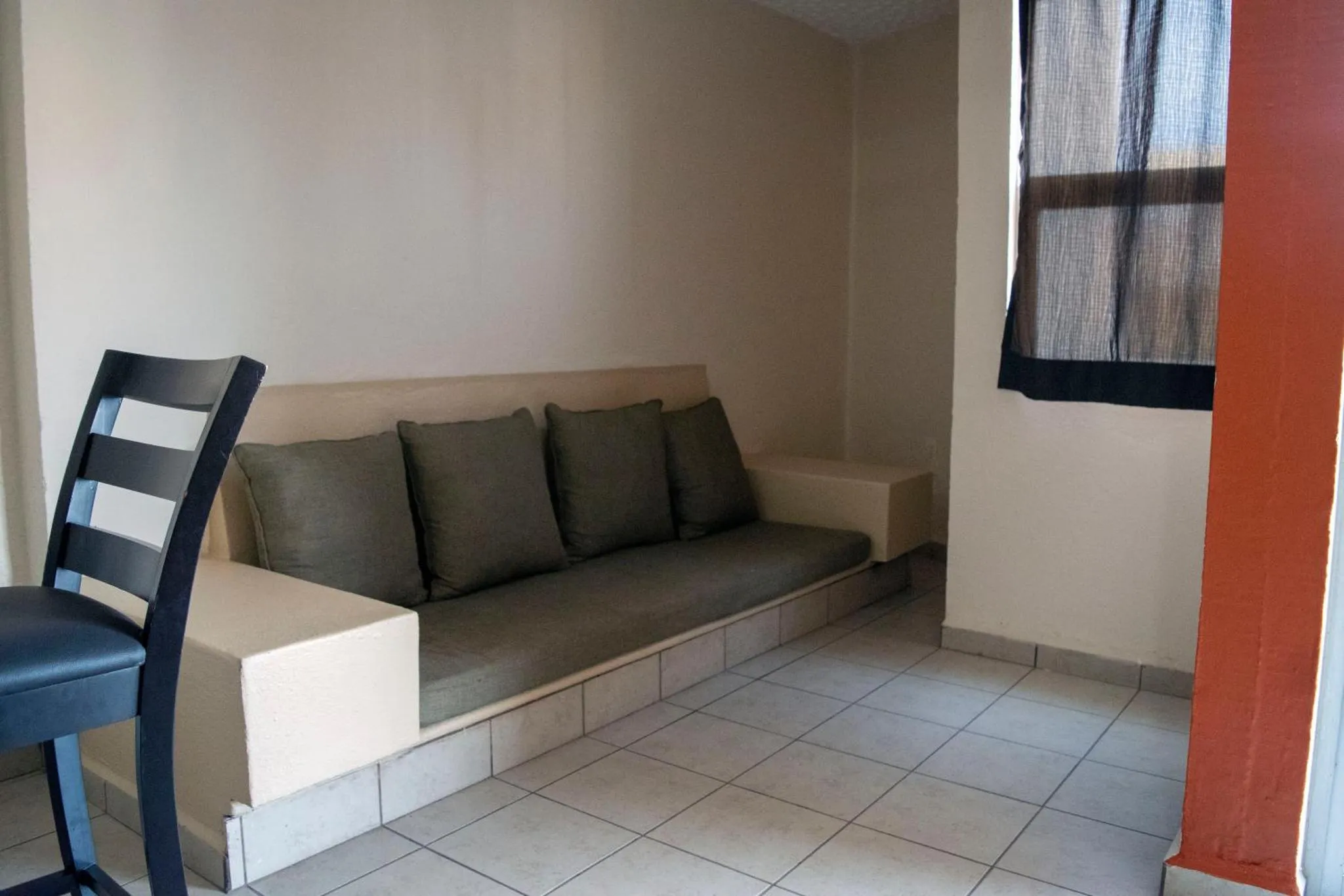 Espace de détente avec canapé intégré et coussins verts.