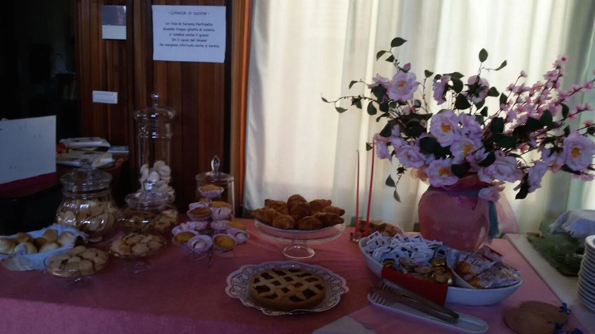 Une table garnie de pâtisseries et de viennoiseries est présentée dans un intérieur clair.