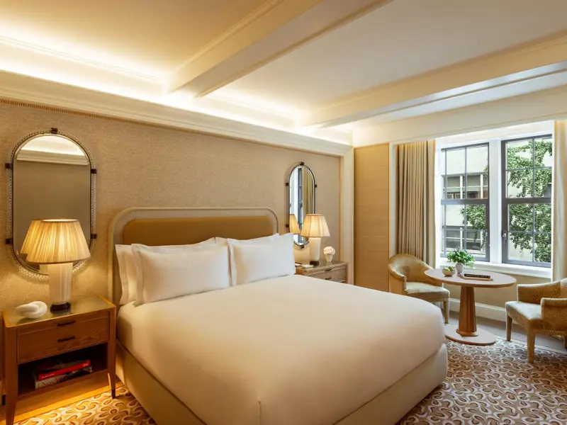 Une chambre lumineuse avec un grand lit et une fenêtre.