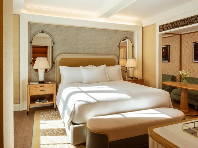 Une chambre lumineuse avec un grand lit et des tables de chevet.