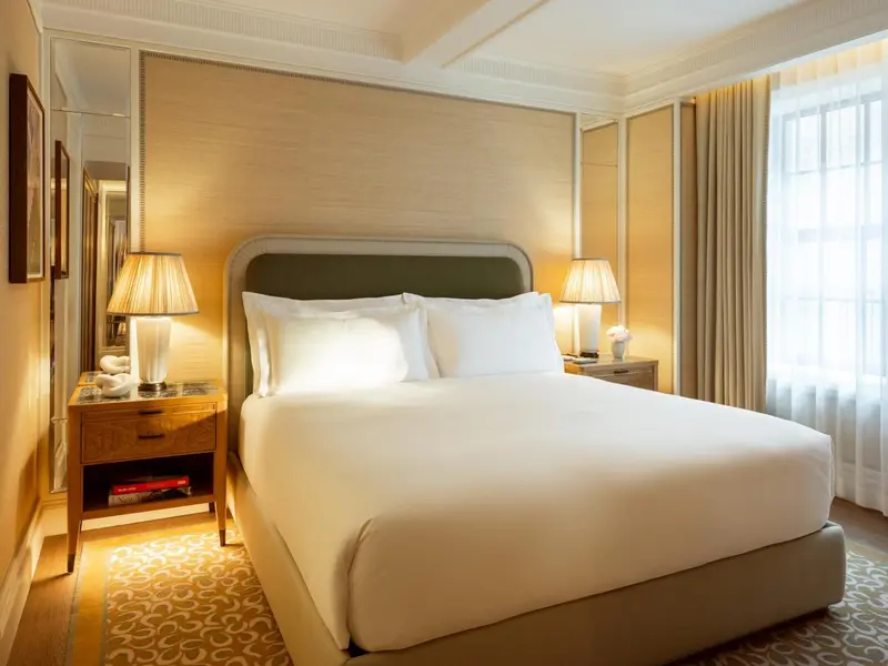 Une chambre lumineuse avec un grand lit recouvert d'une courtepointe blanche.