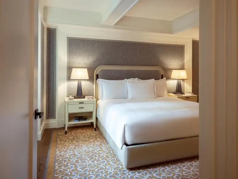 Une chambre lumineuse avec un grand lit et des tables de chevet.