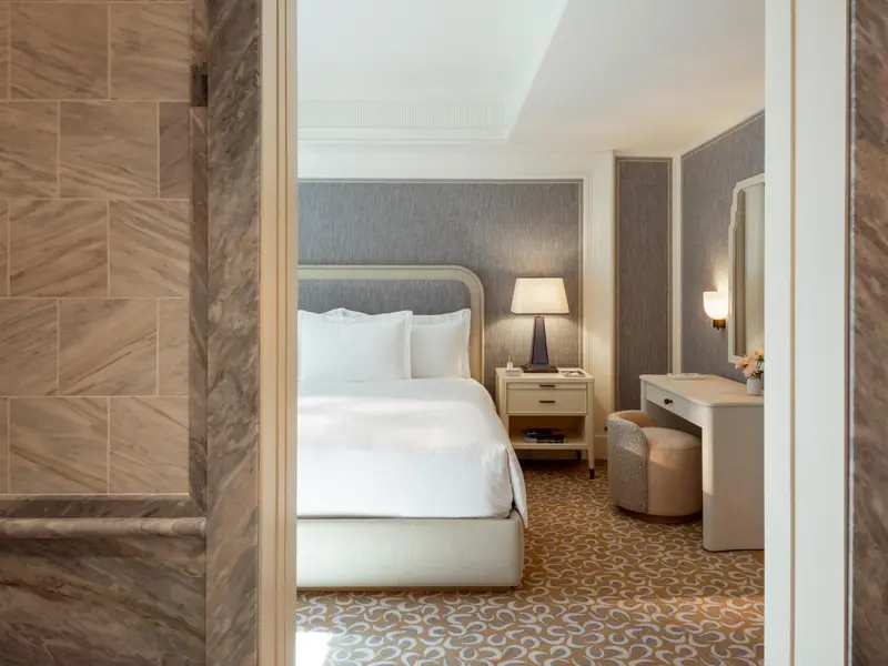 Une chambre lumineuse avec un lit double et un coin coiffeuse.