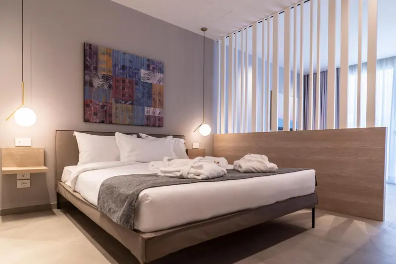 Une chambre moderne avec un grand lit et une décoration sobre.