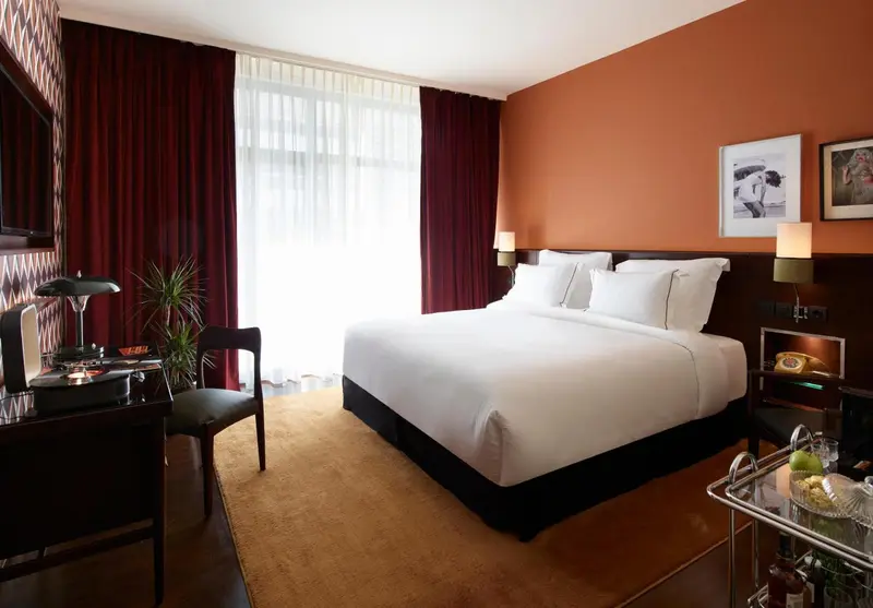 Une chambre d'hôtel lumineuse avec un grand lit et un bureau.