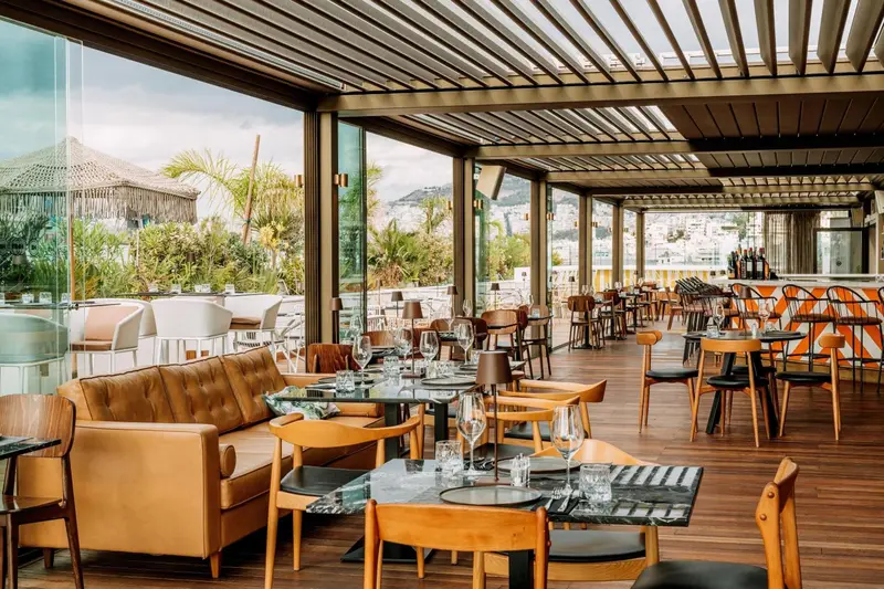 Une salle à manger lumineuse avec des tables dressées et des canapés confortables.