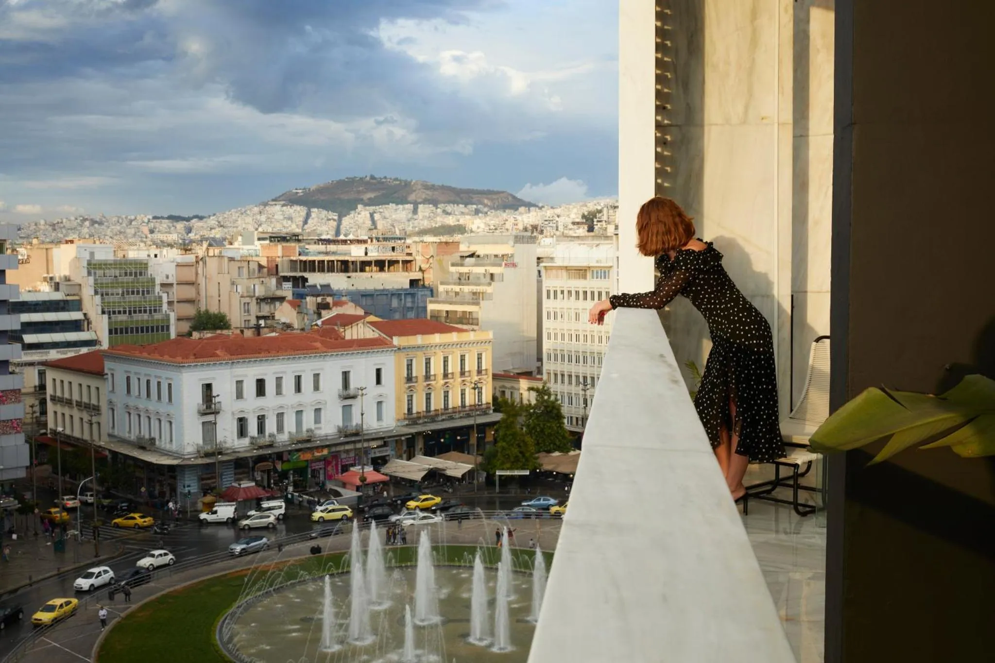 Une personne observe la ville depuis un balcon ou une terrasse.