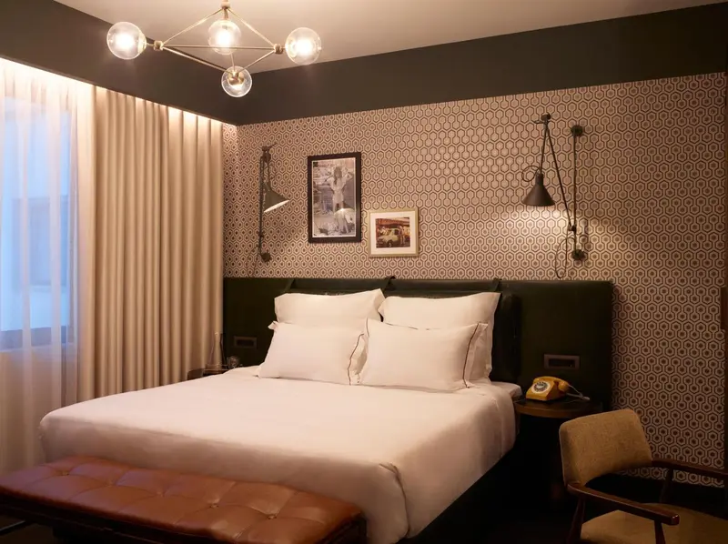 Une chambre avec un grand lit recouvert de draps blancs et de coussins.
