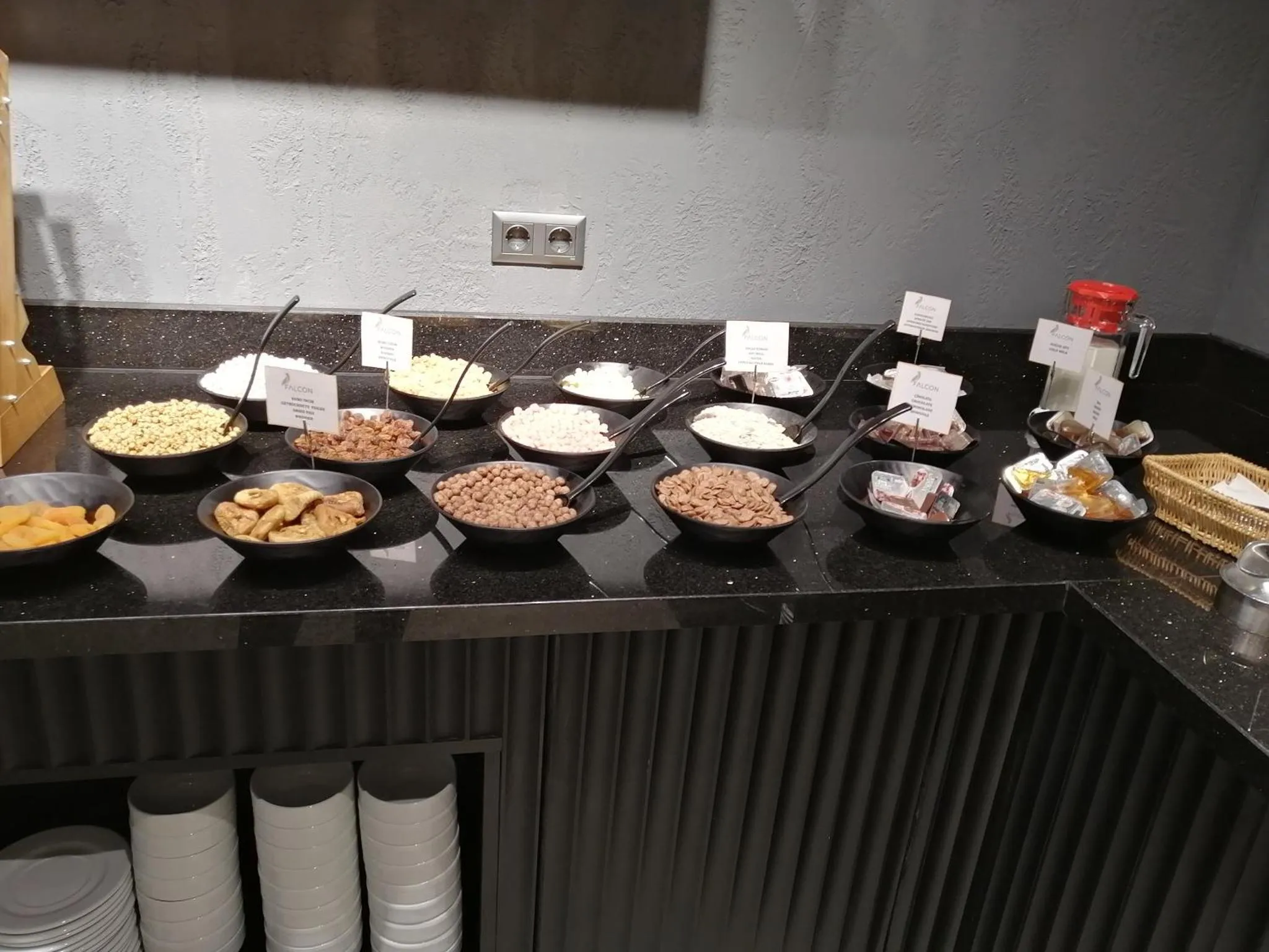 Un buffet propose une variété de céréales, de fruits secs et de pâtisseries.