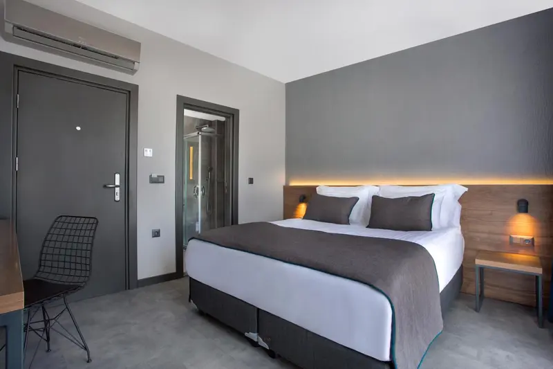 Une chambre moderne avec un grand lit et une décoration sobre.