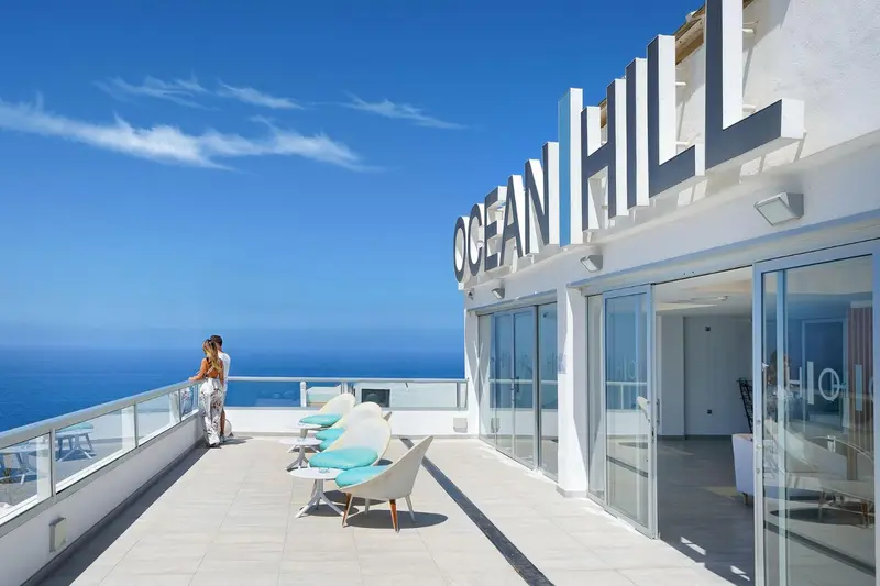 Terrasse avec mobilier d'extérieur et vue sur la mer.
