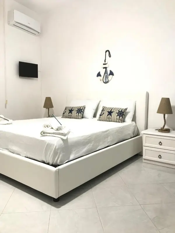 Une chambre lumineuse avec un grand lit et une décoration maritime.
