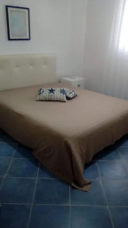 Une chambre avec un grand lit recouvert d'une couverture.