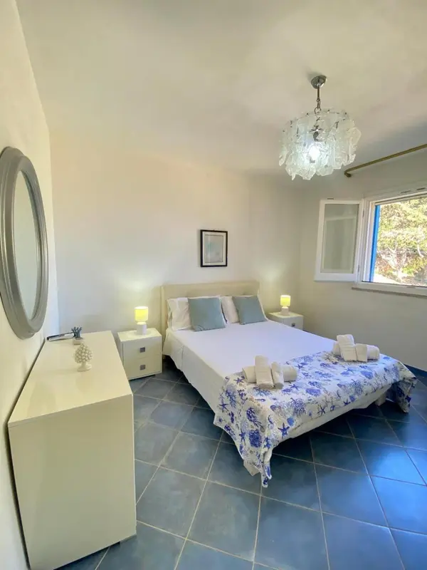 Une chambre lumineuse avec un grand lit recouvert d'une courtepointe décorative.