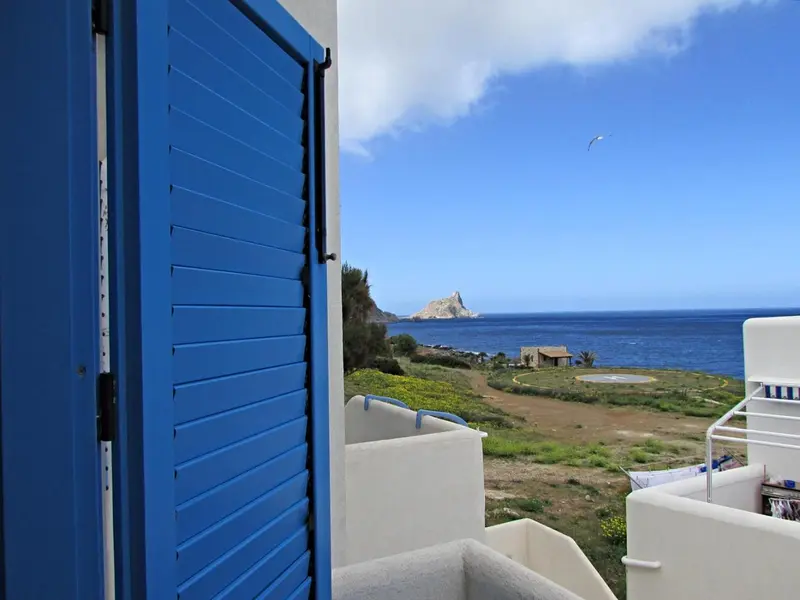 Vue sur la mer depuis une terrasse ensoleillée.