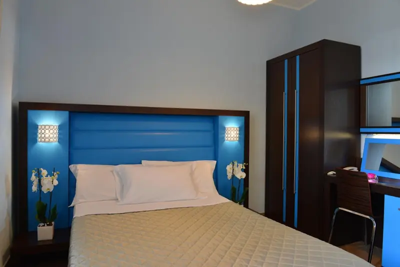 Une chambre avec un grand lit et un meuble de rangement.